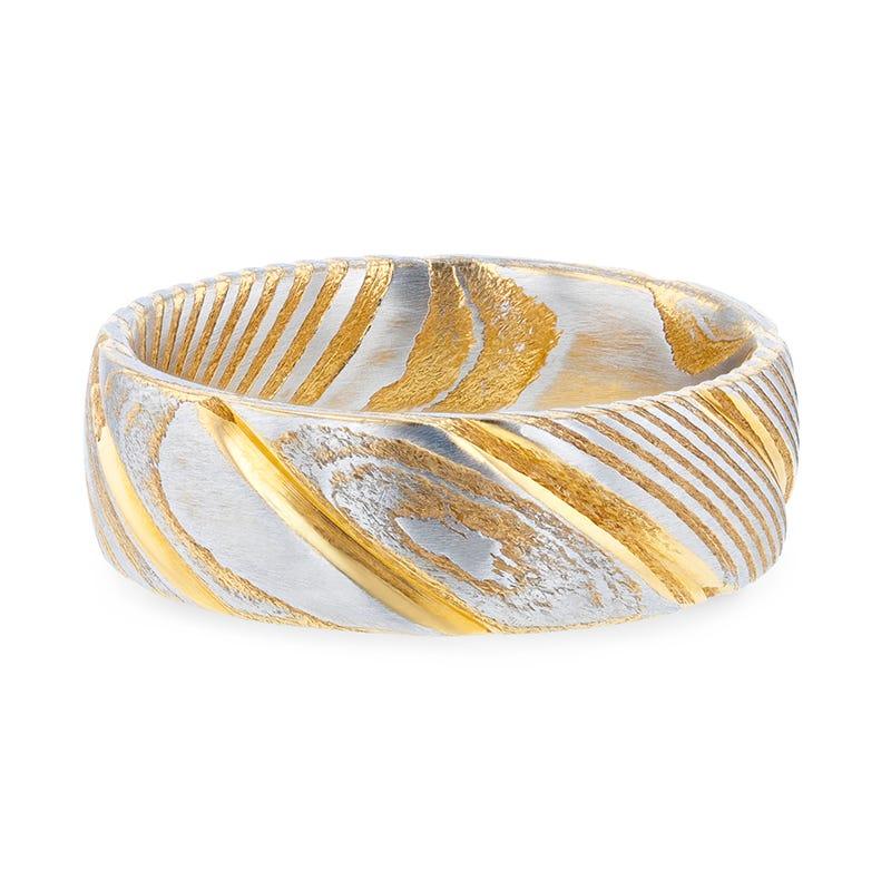 Two-tone gold and silver ring with 'Damascus Steel' branding on a white background