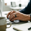Man wearing the Galileo black tungsten wedding band while working at a desk